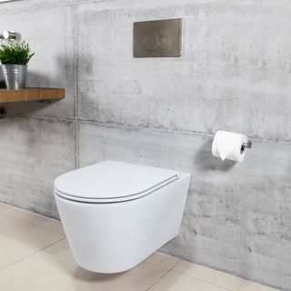 White closed toilet attached to grey stone wall