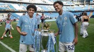 Rico Lewis and Oscar Bobb with the Premier League trophy