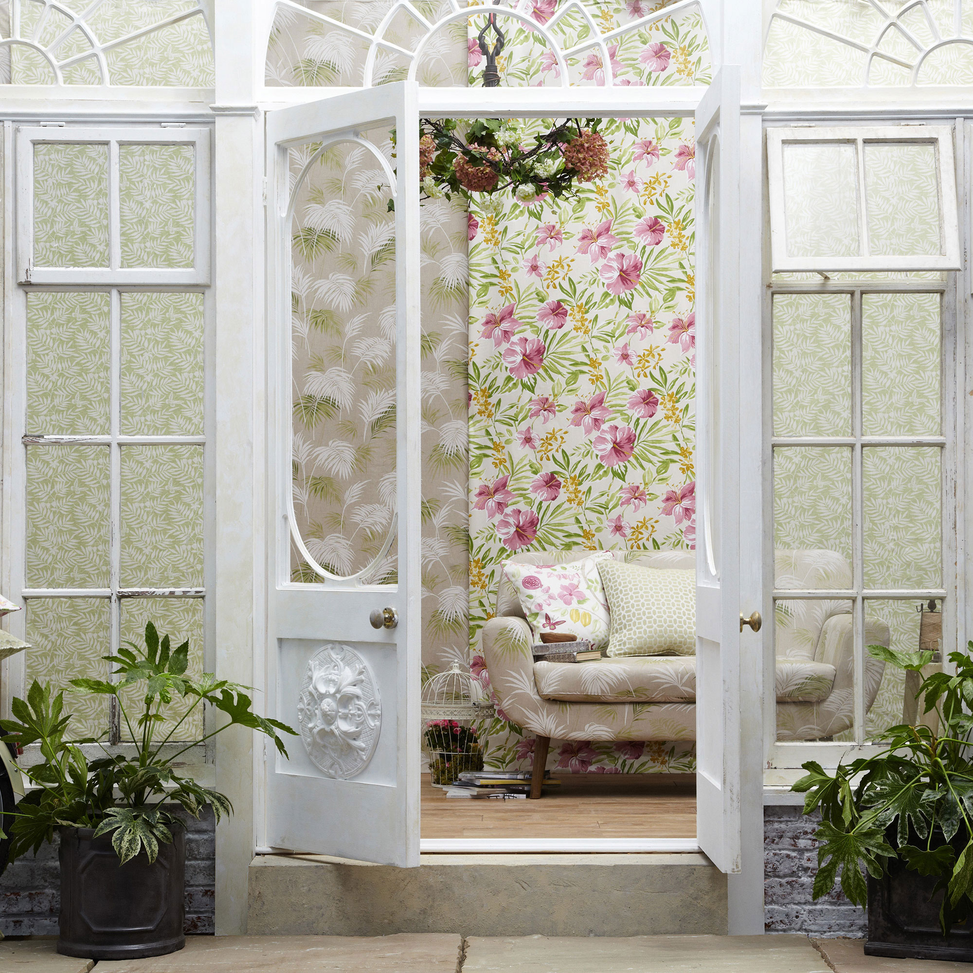 traditional white conservatory living room with floral wallpaper and cream sofa