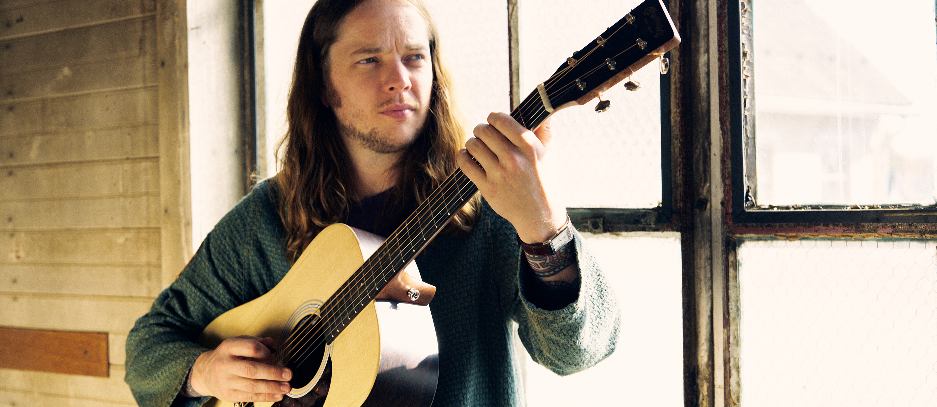 Billy Strings poses with his Martin DX-2E Billy Strings acoustic-electric