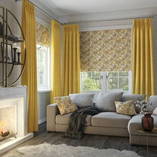 Yellow curtains and blinds with grey sofa and fireplace