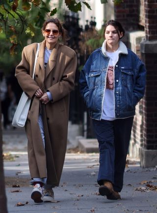 Katie Holmes and Suri Cruise walk together in Manhattan wearing a camel coat and a trucker jacket