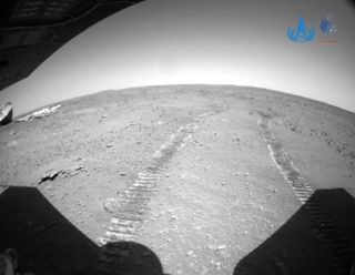 This hazard-camera shot of Zhurong's parachute and backshell, taken on July 12, 2021, also features the rover's tracks.