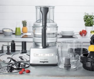 Magimix food processor on the countertop with the accessories around it