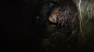 Callie Hernandez panicing while stuck in a log in Blair Witch.