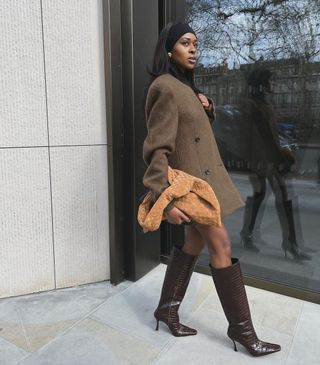 Stiefeltrends Herbst 2024: Influencer trugen braune kniehohe Stiefel mit einem braunen Wollmantel und einer braunen Tasche