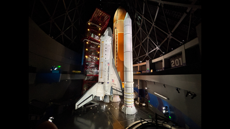 The space shuttle Endeavor stands upright in a museum. 