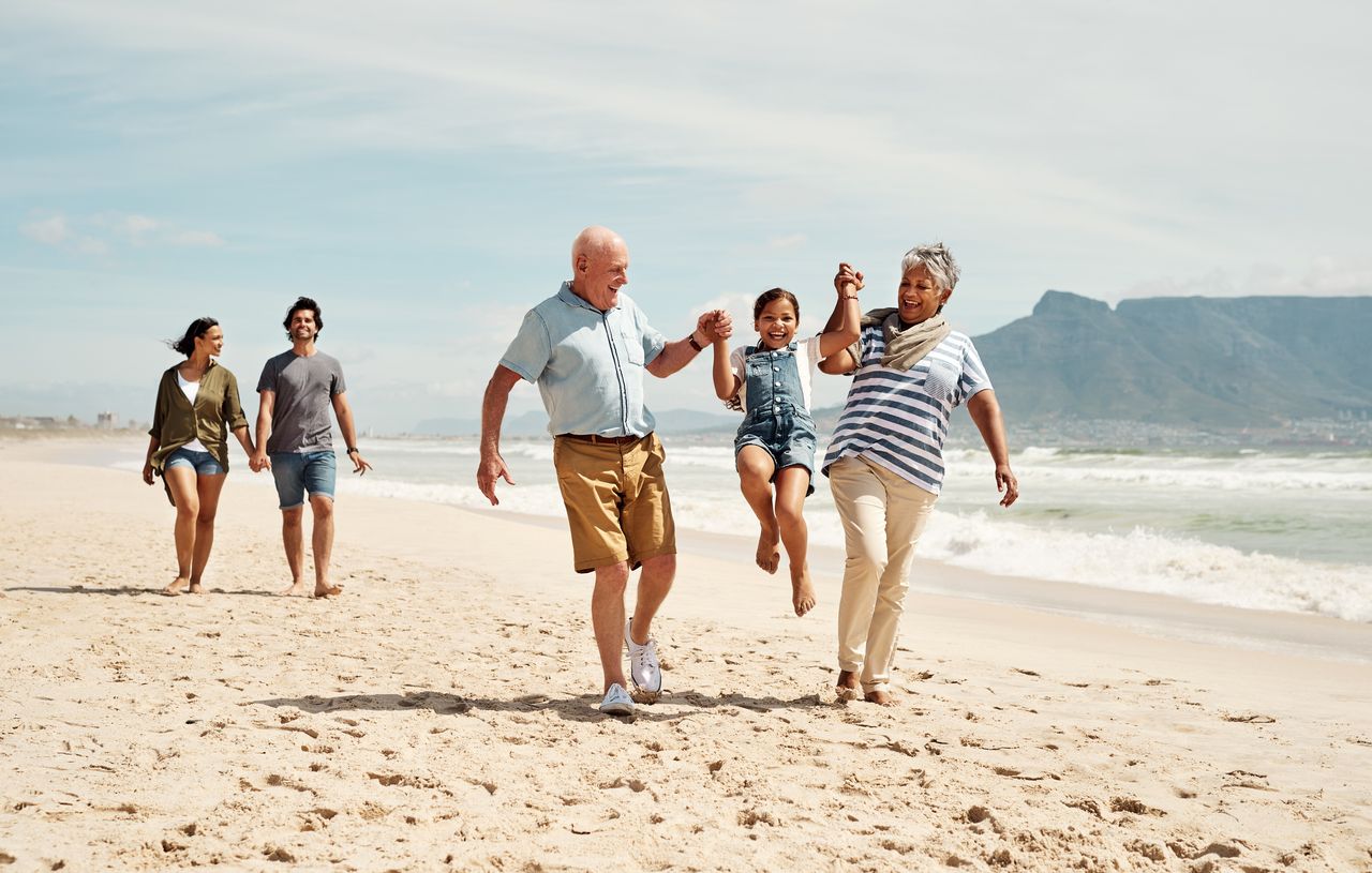 Shot of an adorable little girl having a fun day at the beach with her parents and grandparents