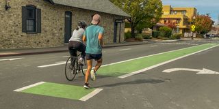 A cyclist and a runner side by side