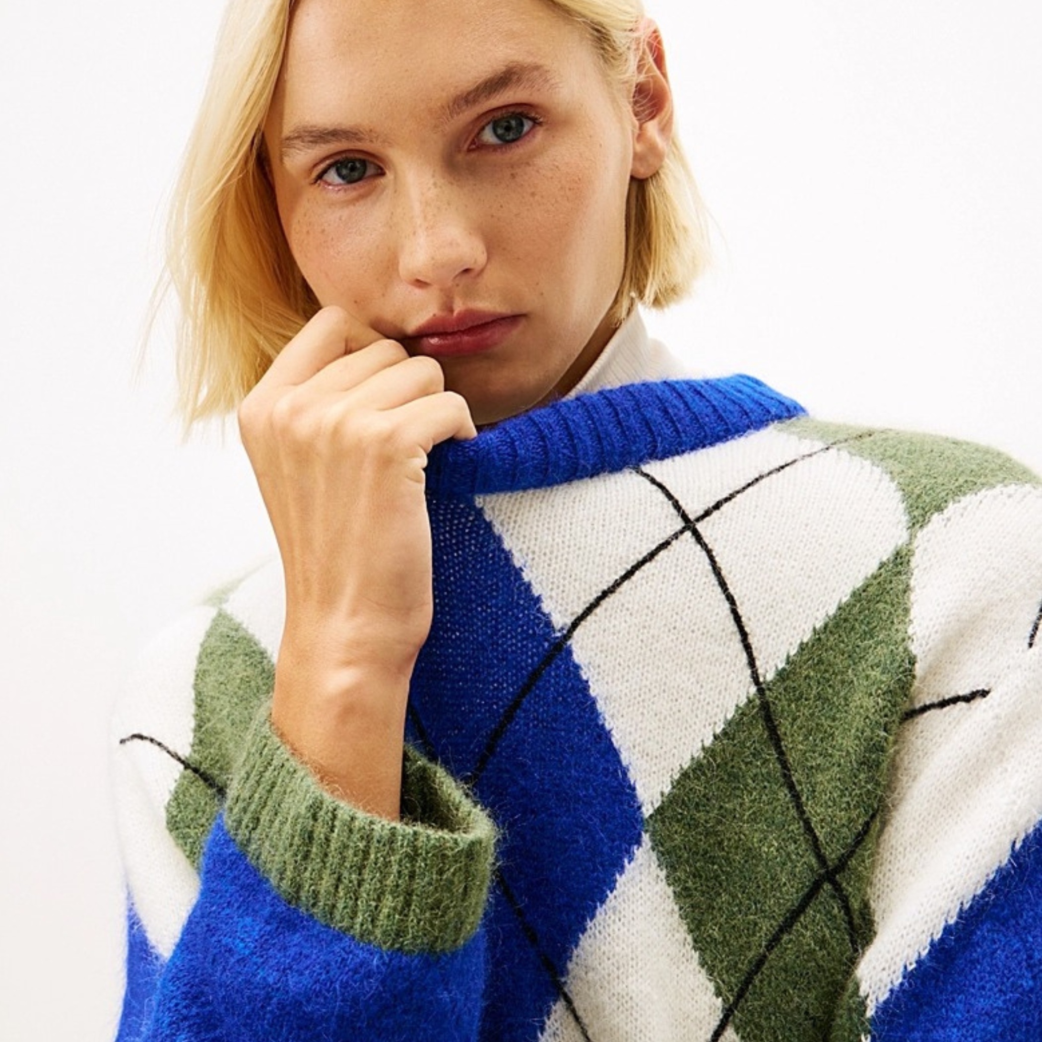 A model wears an argyle sweater from TOMMY HILFIGER. 