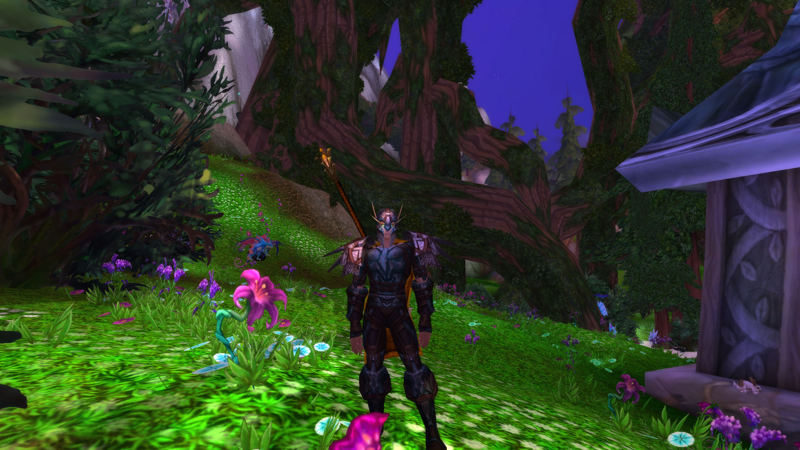 WoW cataclysm hyjal or vashj'ir - a blood elf is standing in a lush meadow near a building