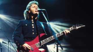 John Wetton (1949 - 2017), of the group Asia, plays bass as he performs on stage at Kan-ihoken Hall, Tokyo, Japan, 25th September 1990.