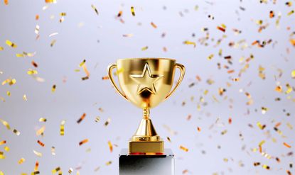 gold trophy with a star on it surrounded by confetti