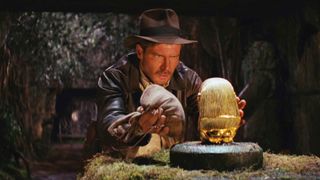 Indiana Jones dans Les Aventuriers de l'Arche perdue est sur le point de prendre une idole en or.