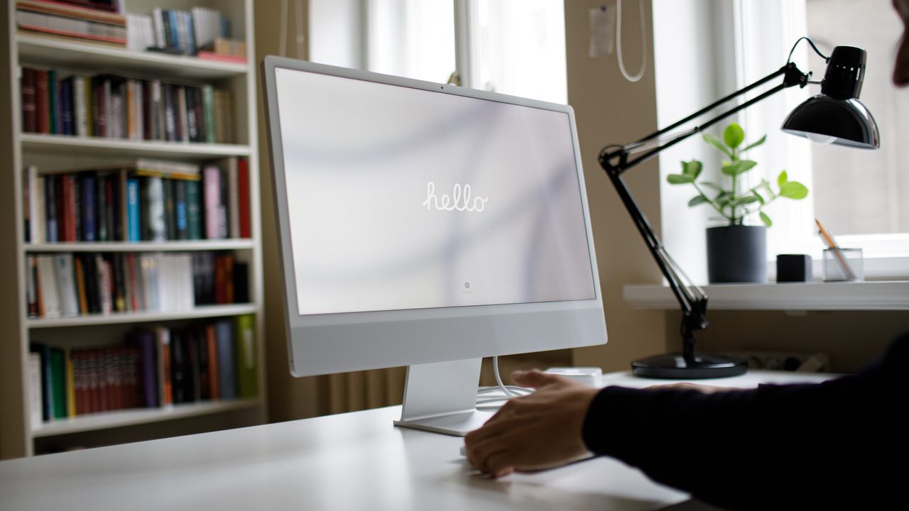 iMac on desk with lamp nearby