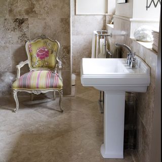 en suite bathroom with tiled walls and white washbasin