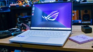 Beste gaming-laptoper: En Asus ROG Zephyrus G14 står åpnet på et skrivebord omgitt av tilbehør-