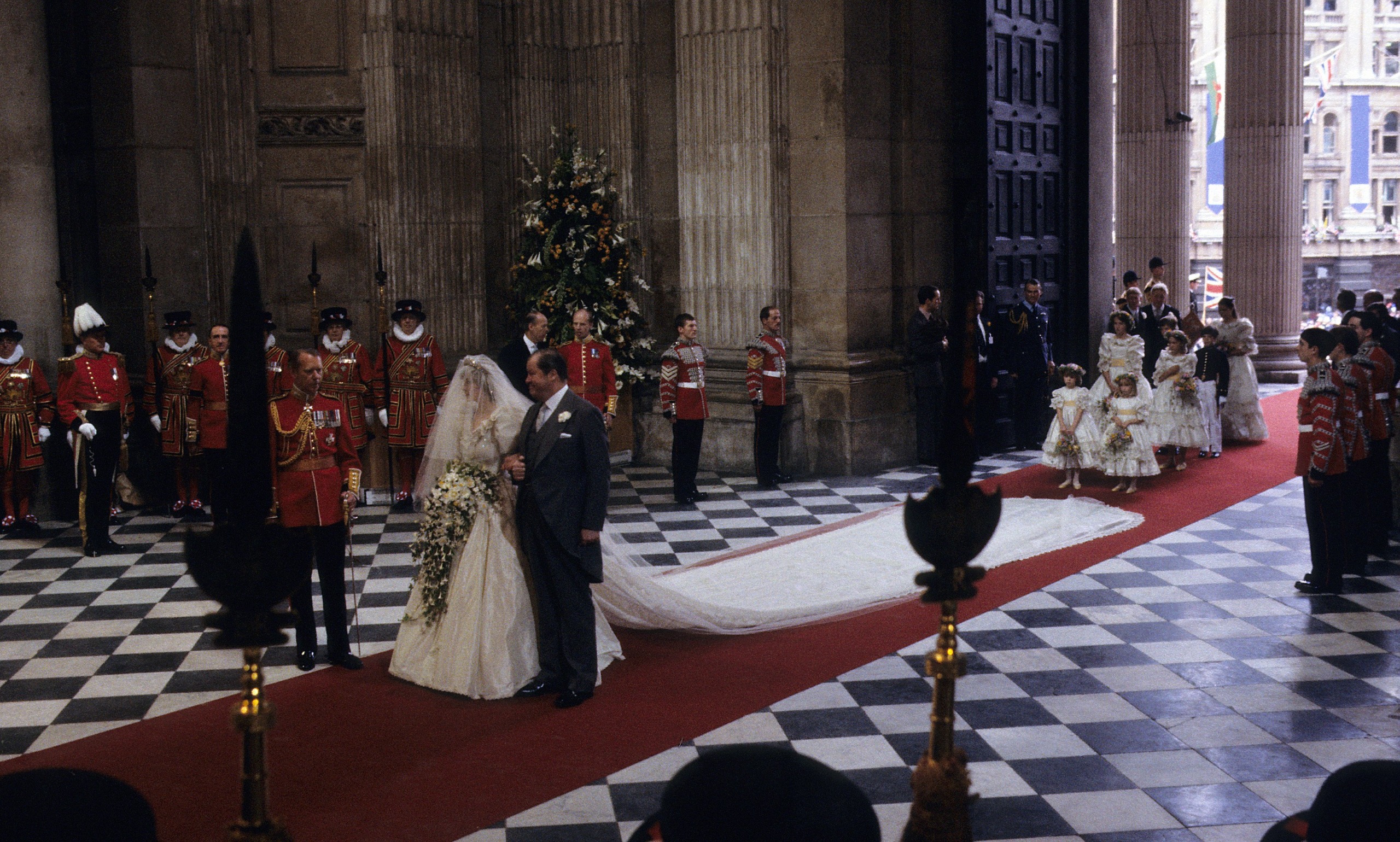 Princess Diana walking down the aisle on her father's arm at her wedding