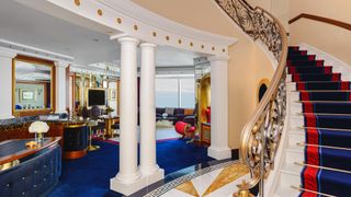 Internal shot of the Marina Suite at the Jumeirah Burj Al Arab, showing ornate staircase, blue carpet and red highlights