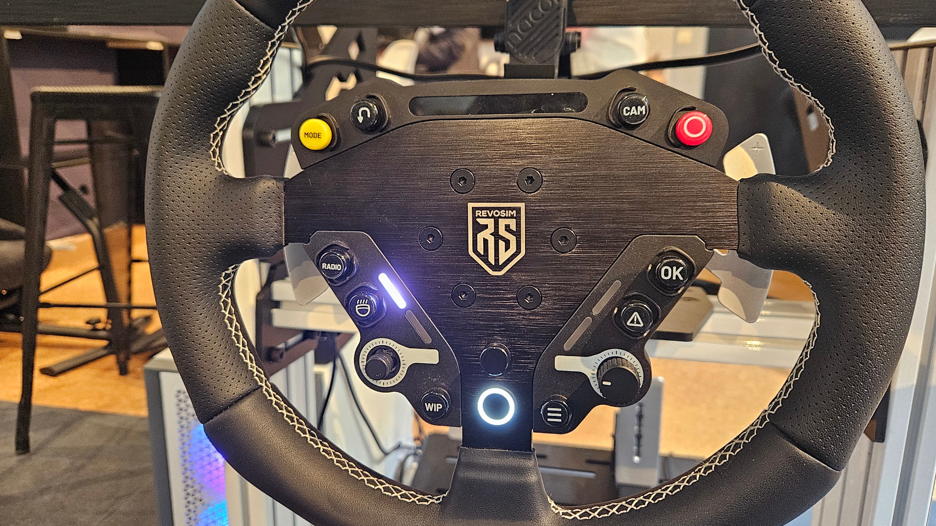 The Nacon Revosim Pure racing wheel set up and ready to use, displayed at Big Ben Week 2025 (photographed by Future)