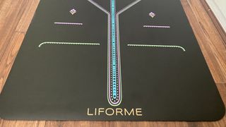 Lifeforme yoga mat on a wooden floor showing alignment design