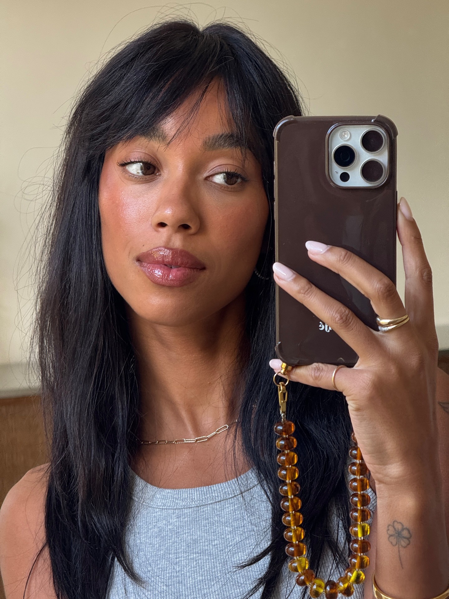 A woman taking a mirror selfie with glowing skin