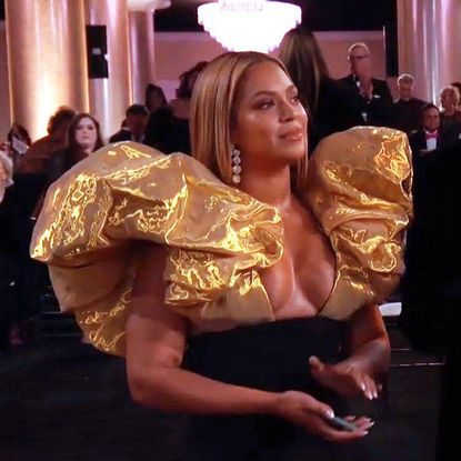 Beyonc&eacute; wearing a top with puffy golden sleeves. 