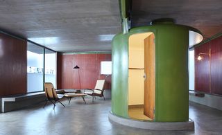 The interior of the house featuring the olive green cylindrical element