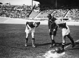 Giuseppe Meazza, captain of the italian team, Nils Eriksen, captain of the Norwegian team, and Alois Beranek the Austrian referee, look at the coin on he lawn to know who will begin the match on June 05, 1938 in Marseille, during the World Cup.