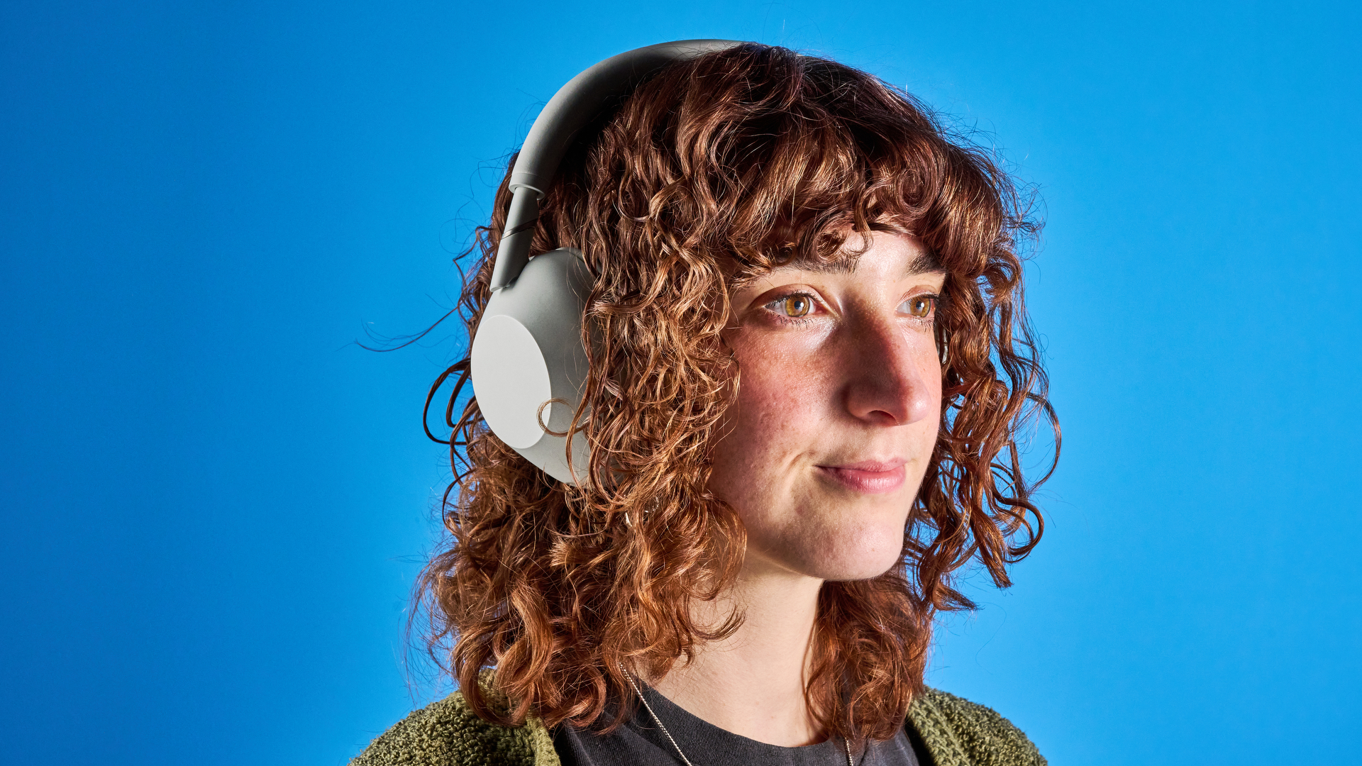 the sony wh-1000xm6 headphones in beige photographed against the blue tom's guide background