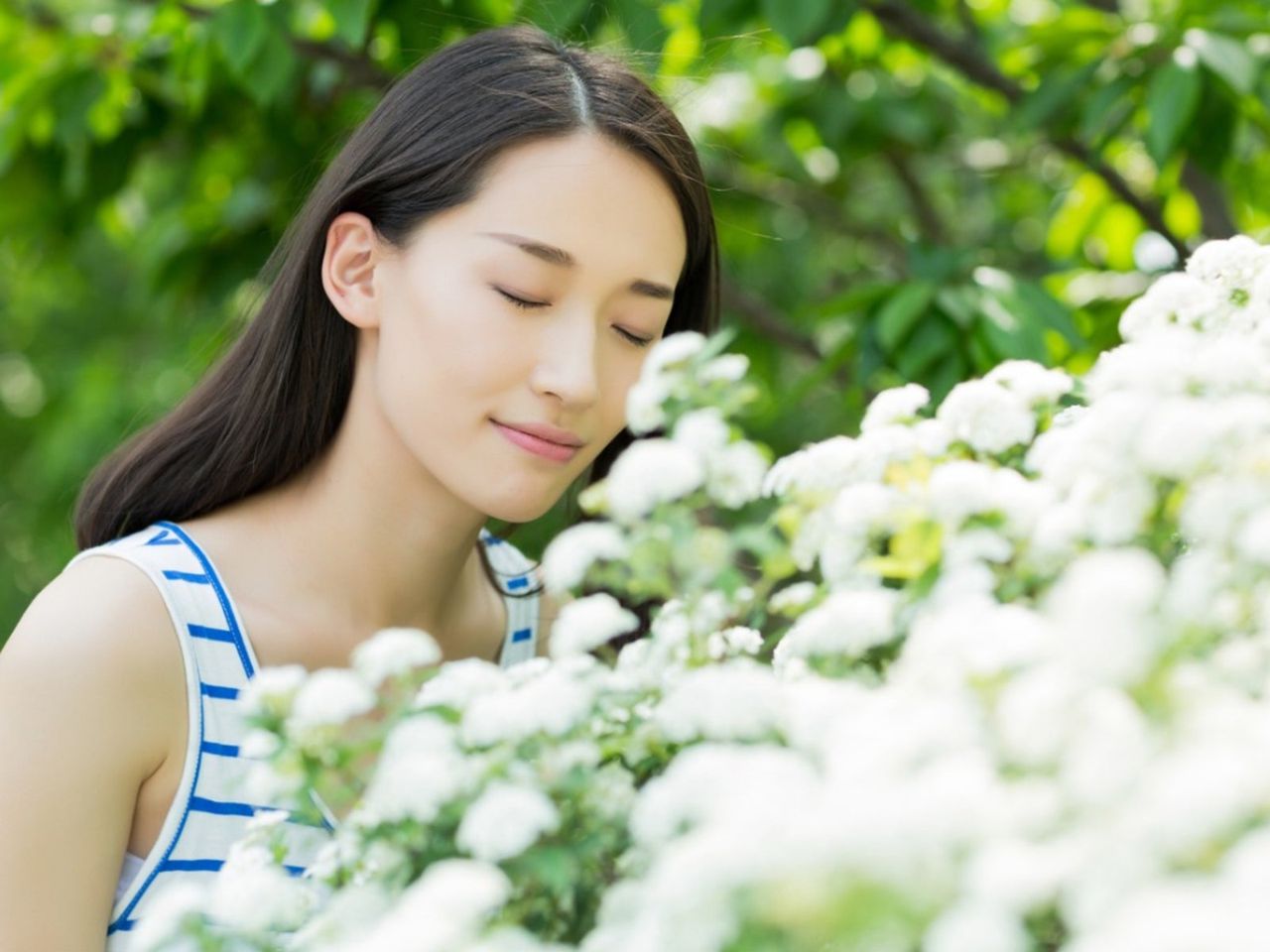 Woman Smelling White Flowers