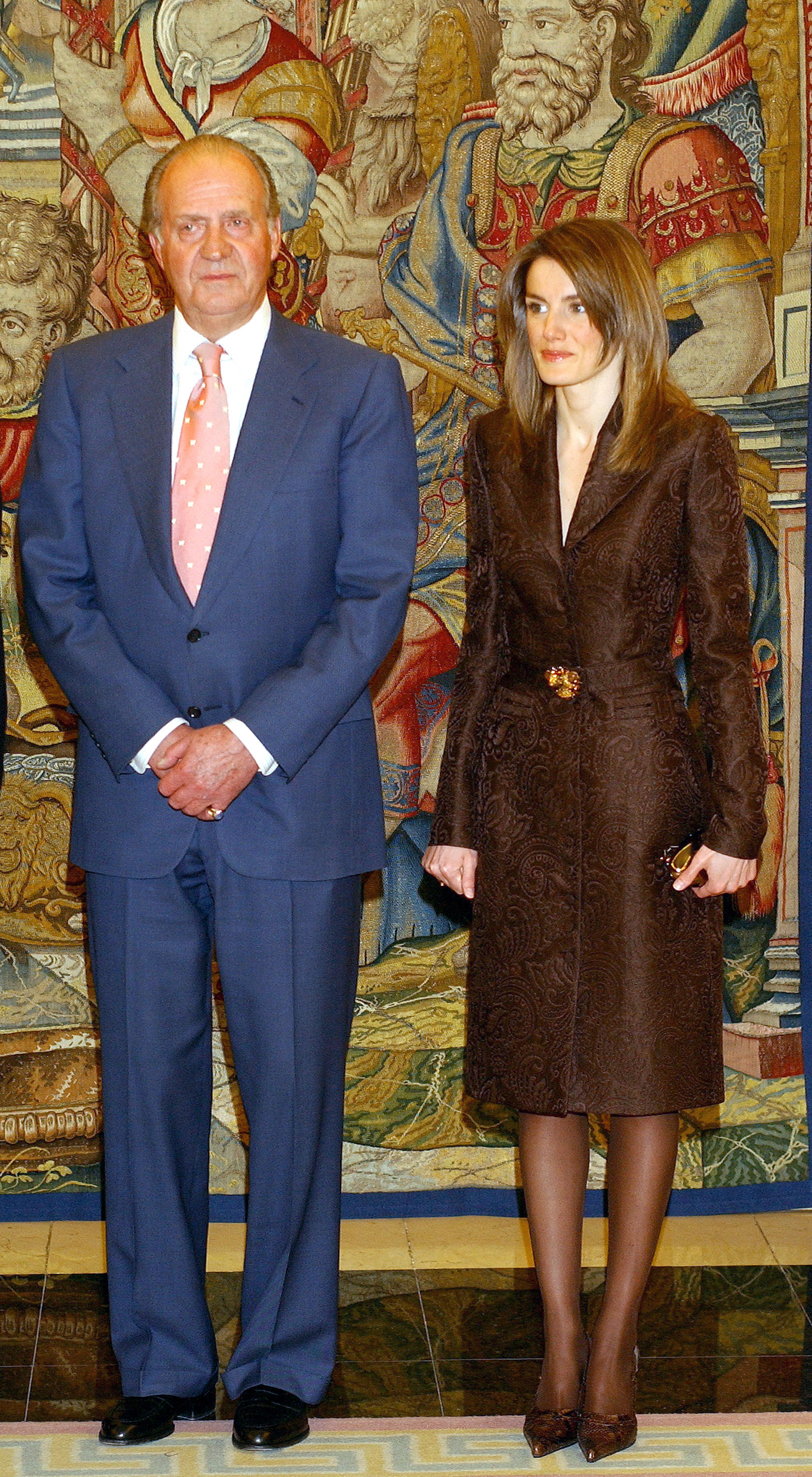 King Juan Carlos and Queen Letizia standing in front of a mural