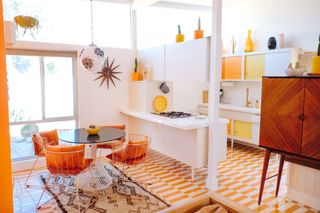 Orange and white straight tiles across open plan kitchen and dining room space with retro bright features