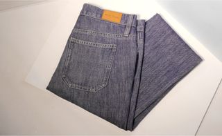 A pair of folded denim jeans