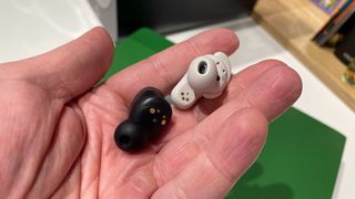 Bose QuietComfort Ultra Earbuds and Bowers & Wilkins Pi8 buds in a hand