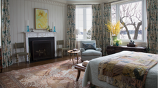 a vintage styled bedroom with lots of old patterned soft furnishings