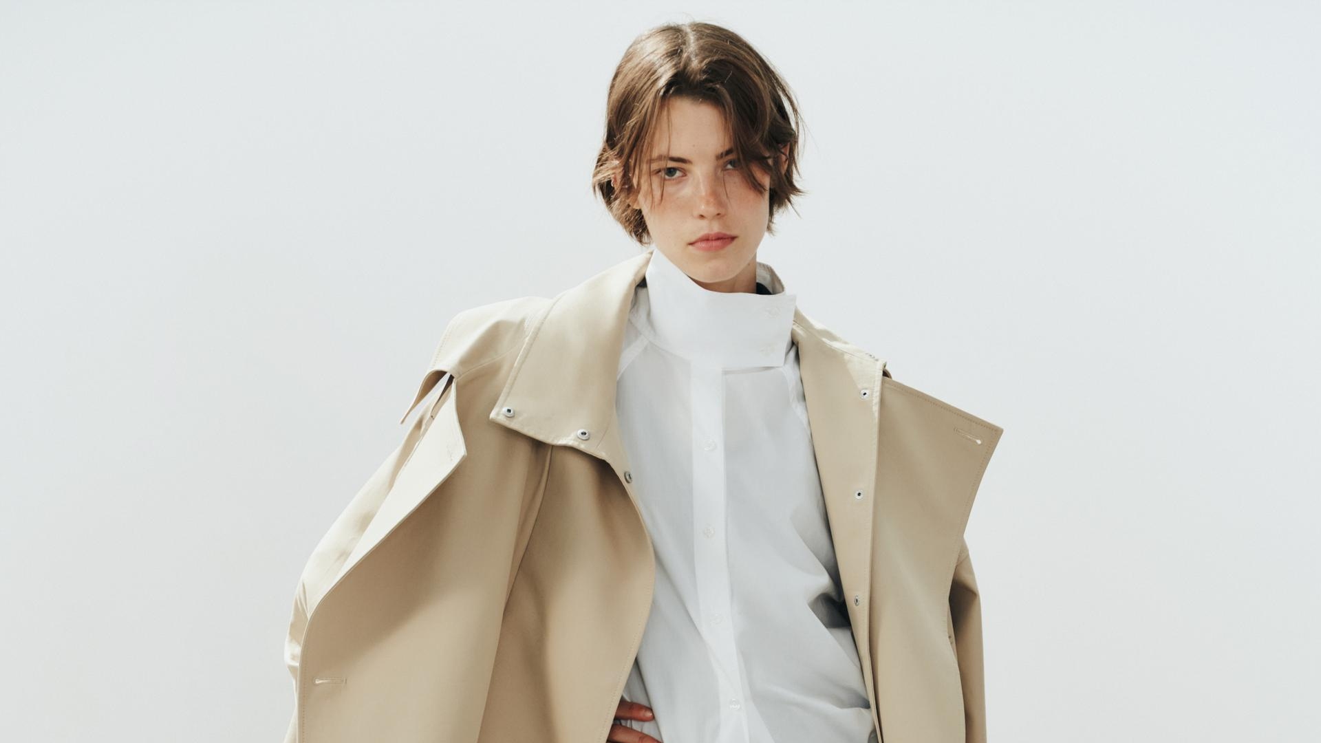 a Zara model wearing a cropped trench coat, white button down shirt and green joggers