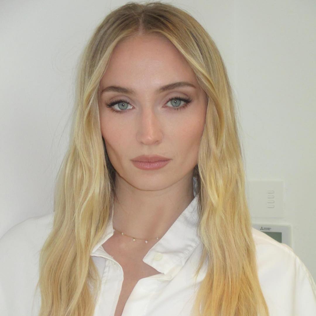 sophie turner with blonde hair and pale makeup