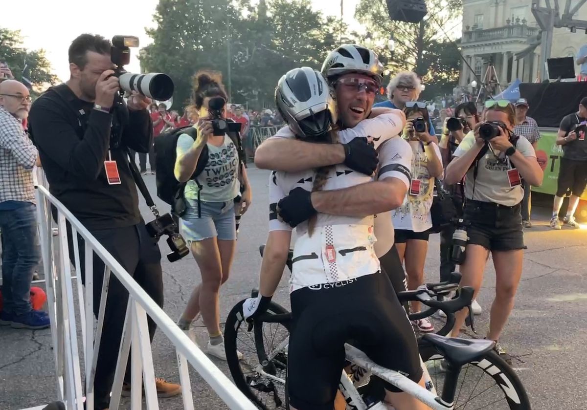 Women's 2023 Athens Twilight Criterium winner Alexis Ryan gets a hug at the finish from teammate Ty Magner