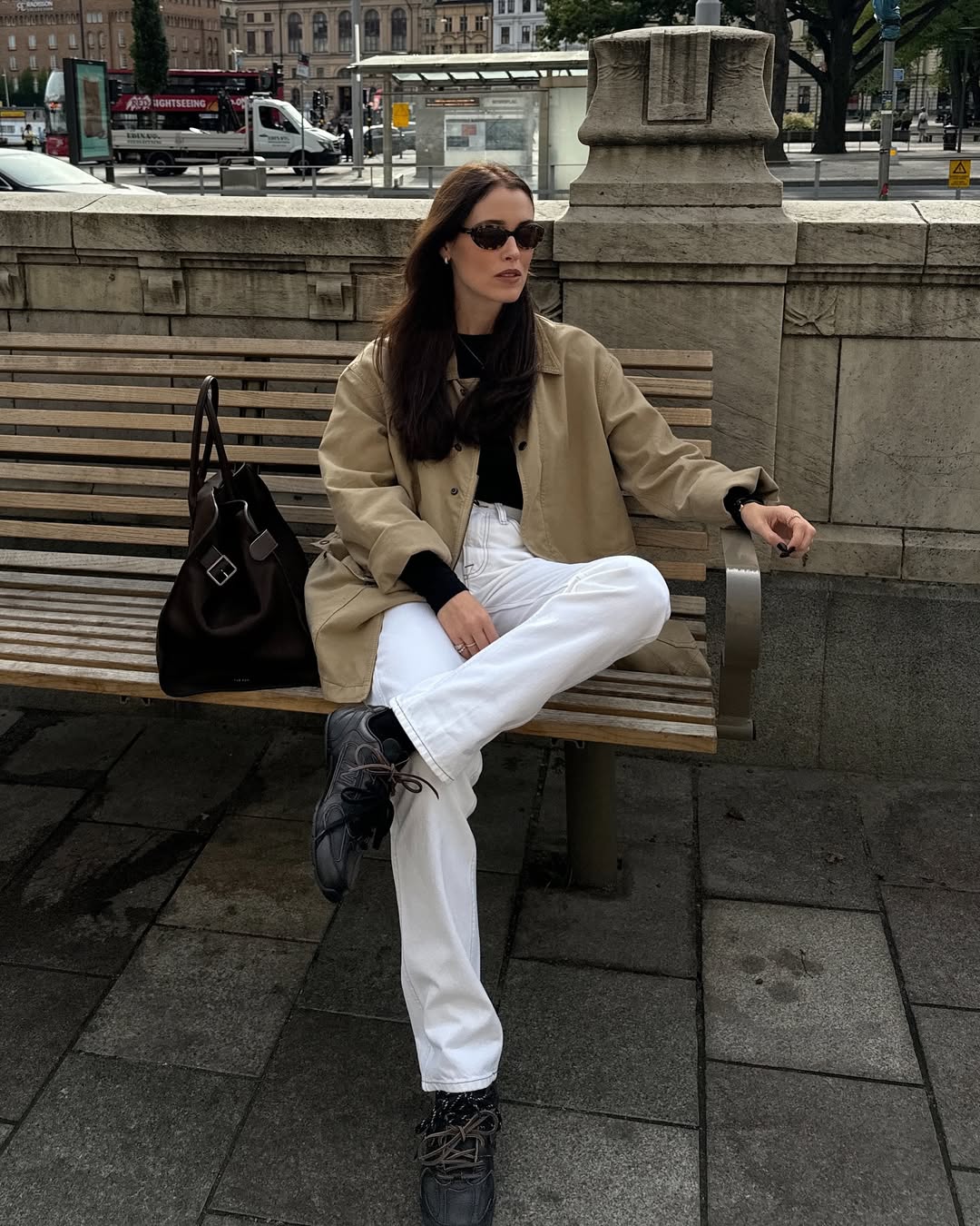 @annabelrosendahl wears black Miu Miu X New Balance 530 trainers with white jeans, a beige canvas jacket and black long-sleeve t-shirt