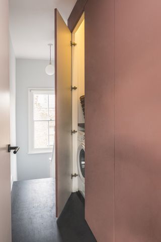 A laundry cabinet by the staircase