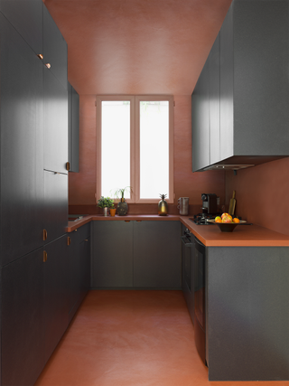 A kitchen with dark grey and pink interiors