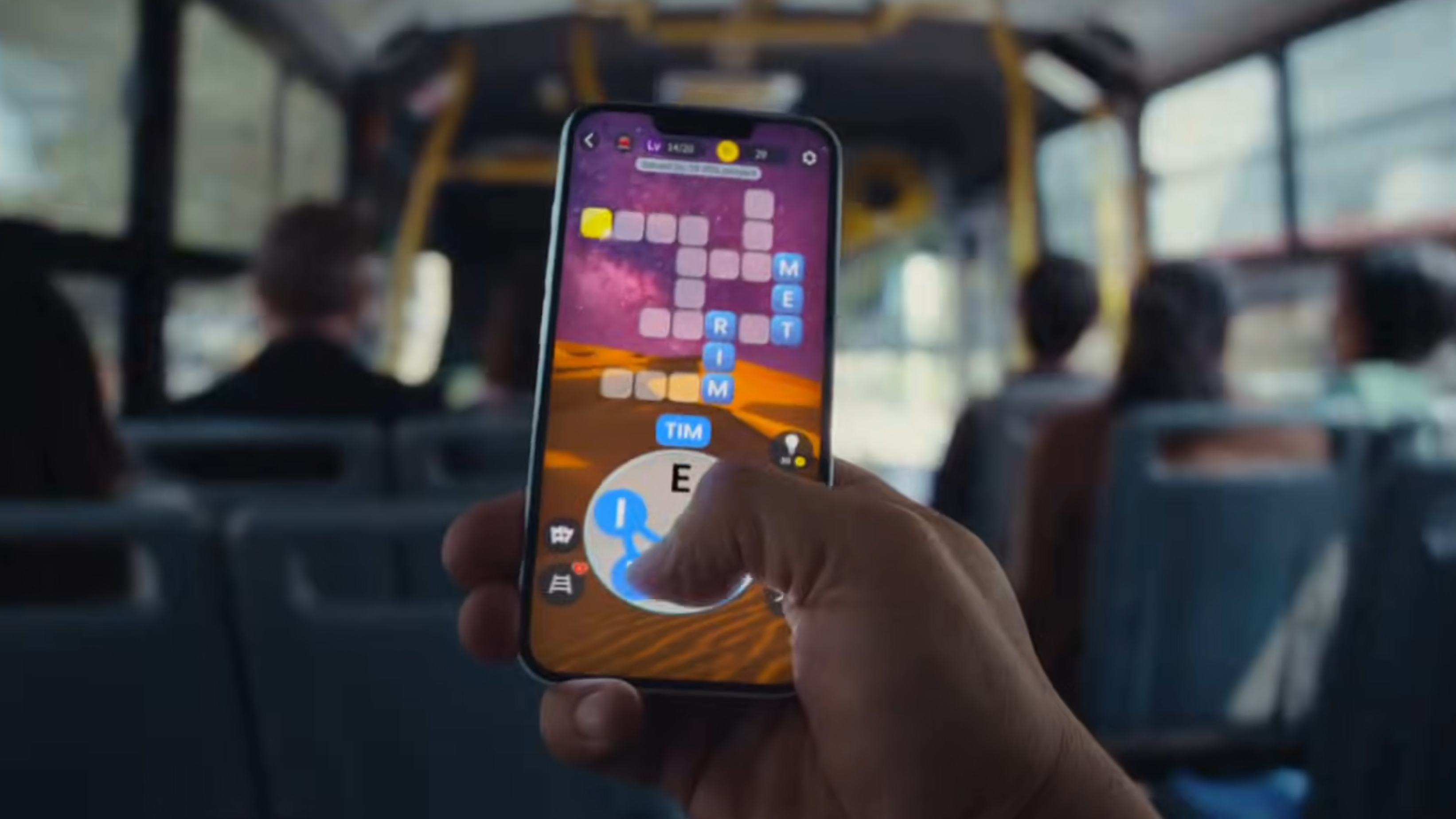A hand holding the iPhone 17e on a bus and playing a game