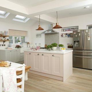 kitchen with white wall ceiling lamp silver refrigerator and wooden flooring