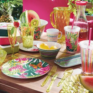 wooden table with tropical plates and glasses