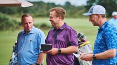 golfers smiling and signing scorecards