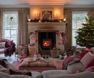 traditional christmas living room with a large fireplace and nancy meyers inspired decor and lots of pink accents