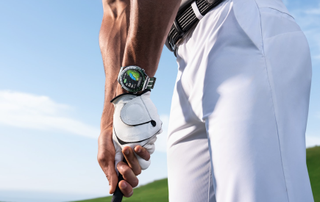 A golfer gripping a club with a HUAWEI watch on their wrist