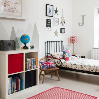kids room with white wall and single bed and bookshelves