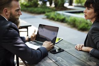 Man and woman talking over laptop